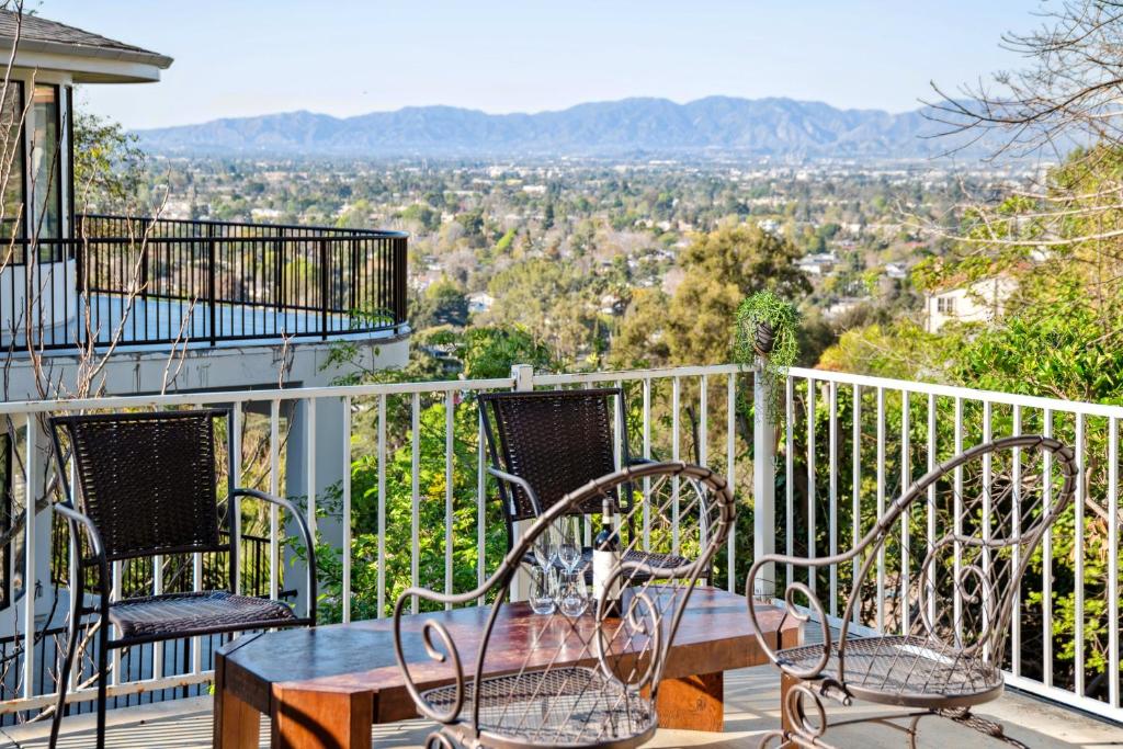a table and chairs on a balcony with a view at Quiet Home with Spectacular Scenic Mountain Views near Universal Studios Hollywood in Los Angeles