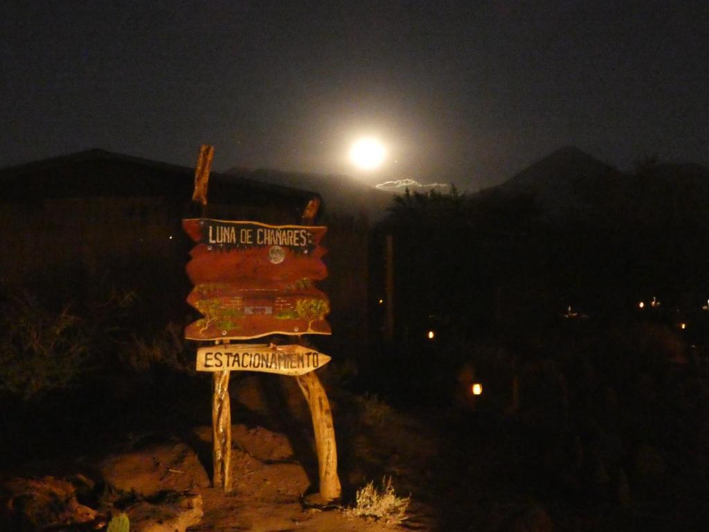 a person standing next to a street sign at night at Luna de Chañares in San Pedro de Atacama