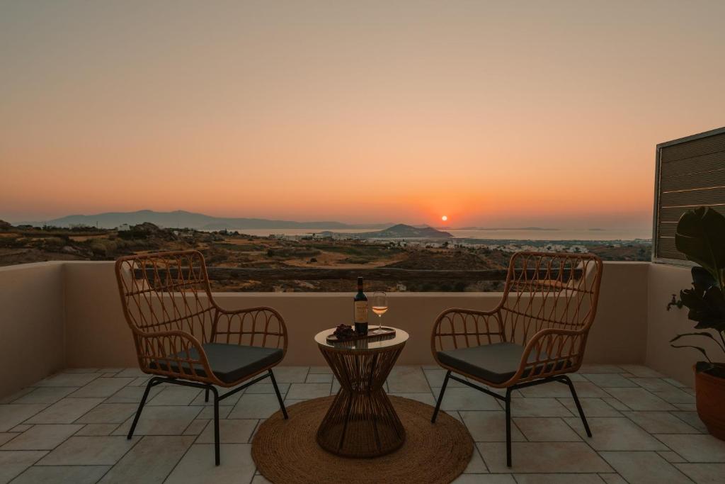 a balcony with two chairs and a table with a bottle of wine at Naxos Tower in Naxos Chora