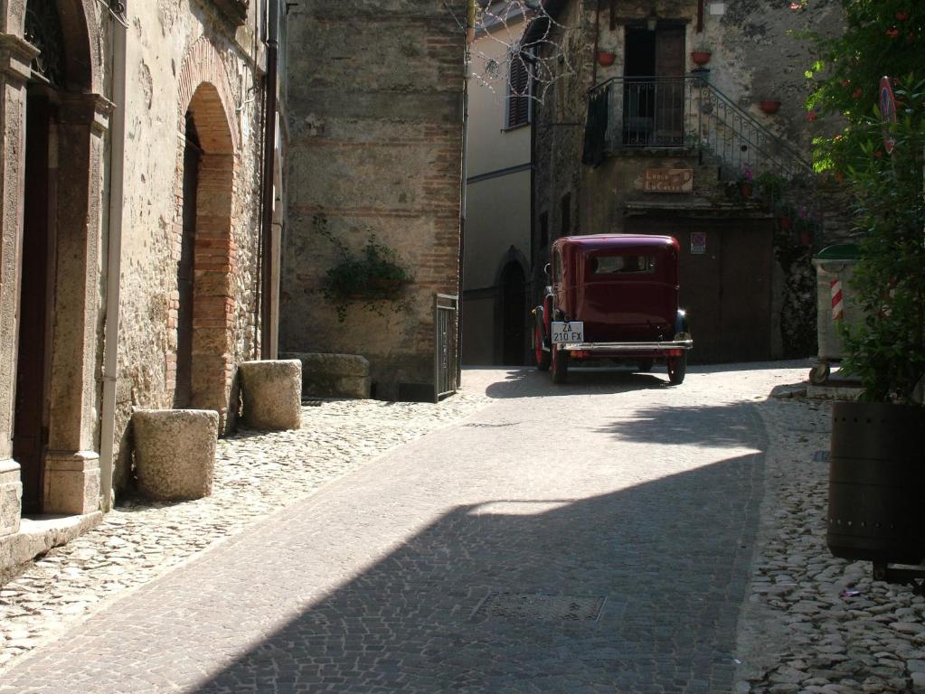 Une vieille voiture rouge descend dans une ruelle dans l'établissement Casa Matilda - Casa Vacanze, à Castel di Tora