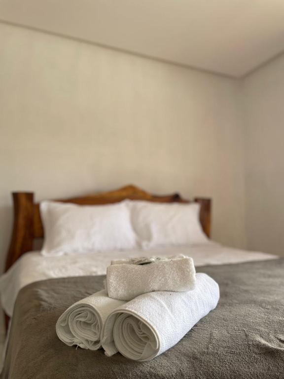 a bed with two towels sitting on top of it at Hotel Fazenda Brisa dos Gerais in Palmeiras