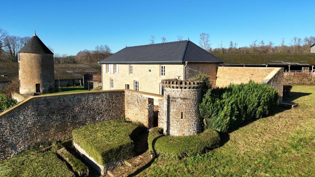an old castle with a wall and a tower at Dépendance du château de Remehan rénovée avec goût in Pouru-Saint-Rémy