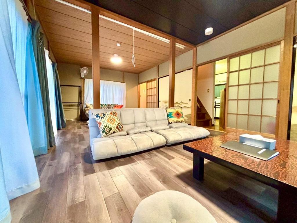 a living room with a white couch and a table at Serenity Oasis Nagatoro in Nagatoro