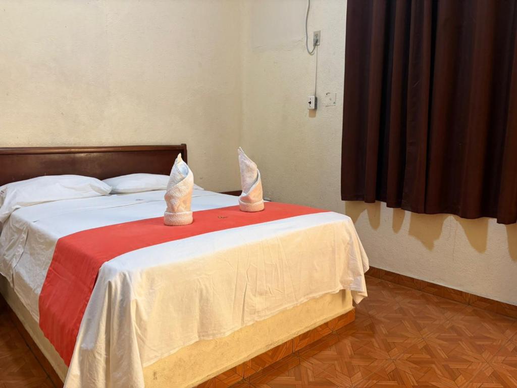 a bedroom with a bed with two rabbits on it at Xpress Inn in Veracruz
