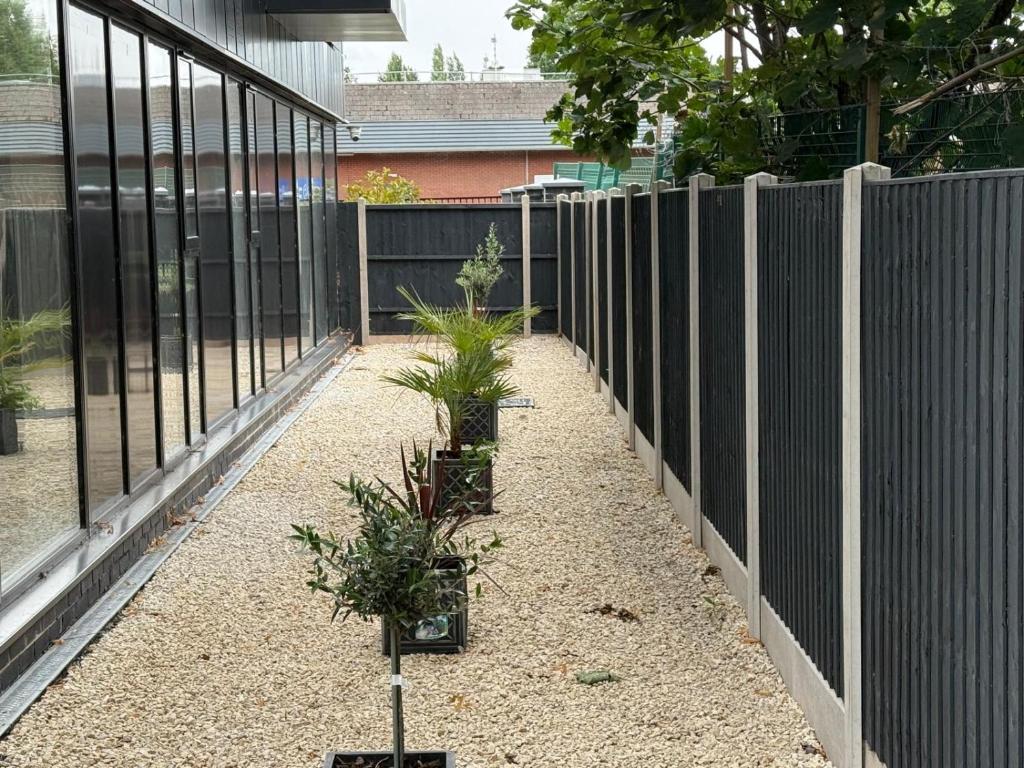 a garden with a fence and plants at Quality City Green Luxury Apts Close to NEC & Airport in Birmingham