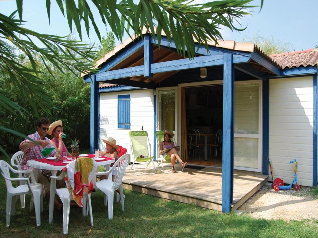 un groupe de personnes assises à une table sur un patio dans l'établissement Chalet in France with Garden Terrace, à Castelmoron-sur-Lot