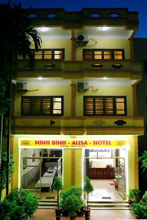 a building with a hotel in front of it at Ninh Binh Alisa Hotel in Ninh Binh