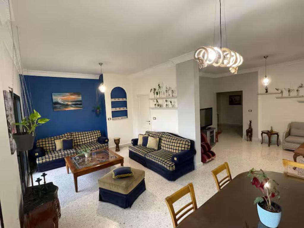 a large living room with couches and a table at antelias mainroad apartment in An Naqqāsh