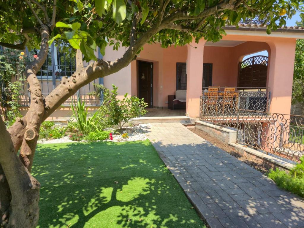 a house with a tree in the yard at Il Bacio di Roma in Infernetto