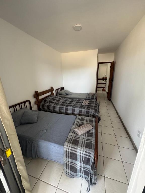 two beds in a room with a tiled floor at Village Pedra do Sal Lounge Apts in Salvador