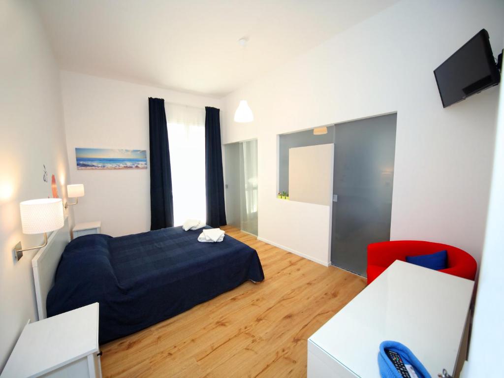 ein Schlafzimmer mit einem Bett und einem roten Stuhl in der Unterkunft Il Faro Trapani B&B in Trapani