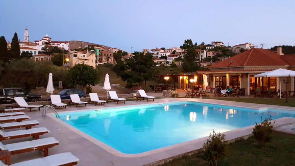 a swimming pool with lounge chairs and a house at Agroktima in Mármaron