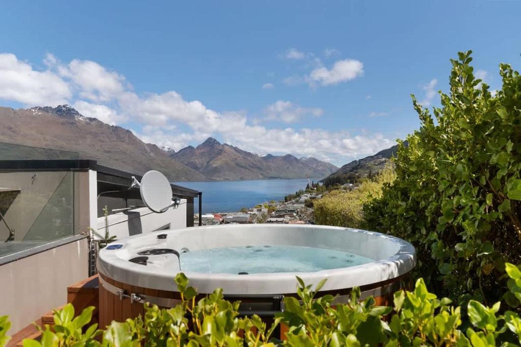 a jacuzzi tub on the balcony of a house at Central Sunset Charm in Queenstown