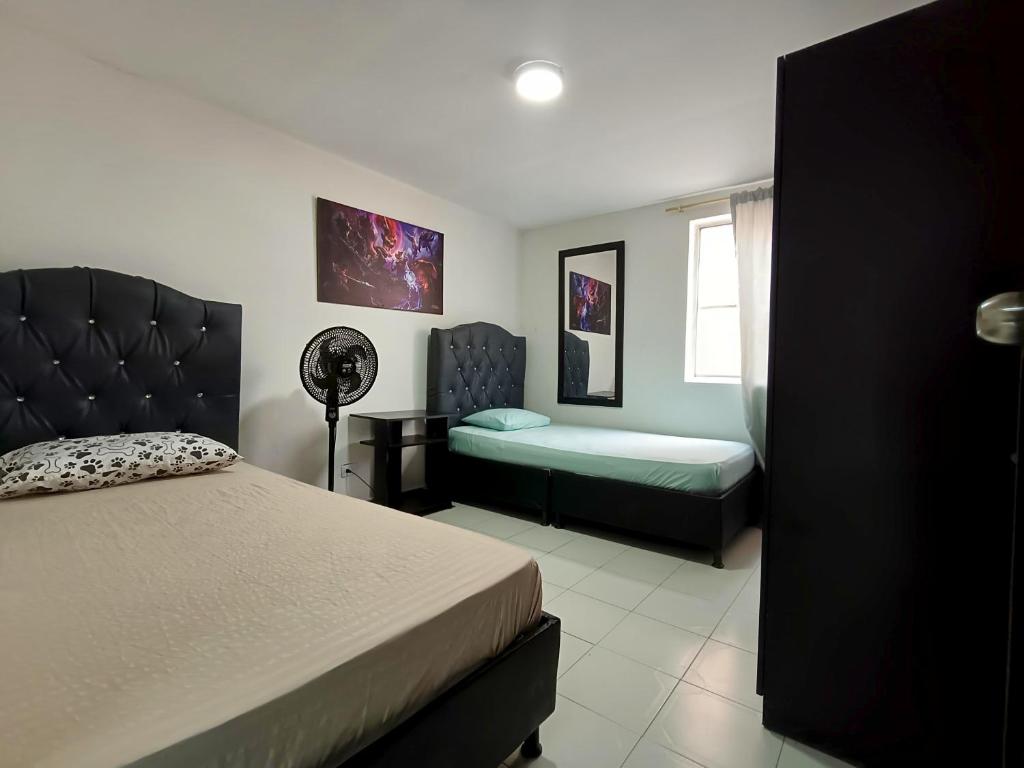 um quarto com uma cama, um sofá e uma janela em Casa Familiar 4 Habitaciones con Agua Caliente, WiFi y Patio - Acepta Mascotas em Pereira