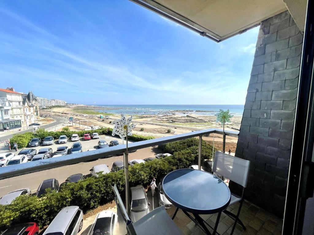 d'un balcon avec une table et une vue sur le parking. dans l'établissement Studio cosy proche plage avec balcon - FR-1-92-822, à Les Sables-dʼOlonne
