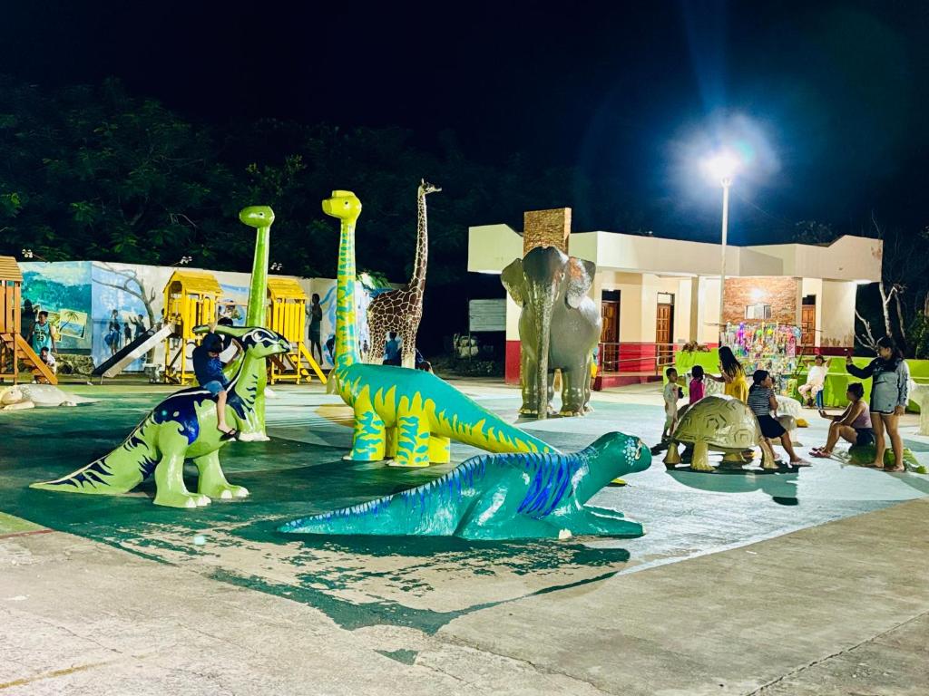a group of dinosaur statues in a park at night at Cockatoo Room Rentals Siquijor in Siquijor