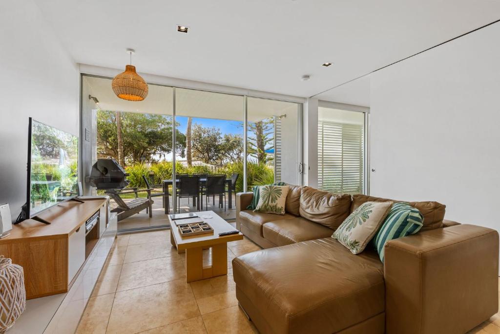 a living room with a couch and a table at Unit 3 Plantation Resort Rainbow Beach in Rainbow Beach