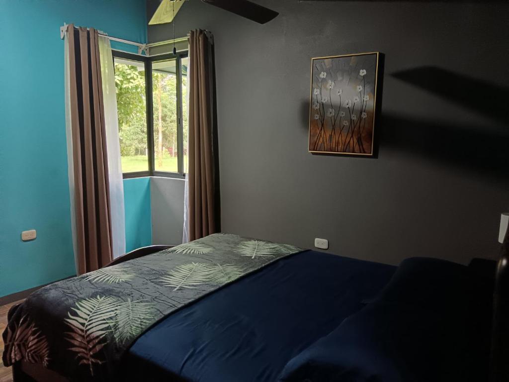 un dormitorio con una cama y una ventana en Club Campestre Champagne, en Chachagua