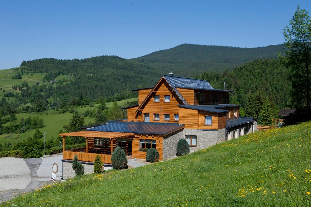 une grande maison au sommet d'une colline dans l'établissement Hotel Havrania, à Zázrivá