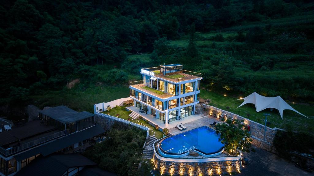 an aerial view of a house with a swimming pool at Zhangjiajie Flowers Valley,Watching Sunrise Cloud Sea, enjoying an infinity pool, free Chinese and Western breakfast, and free shuttle service to the entrance of the National Forest Park in Zhangjiajie