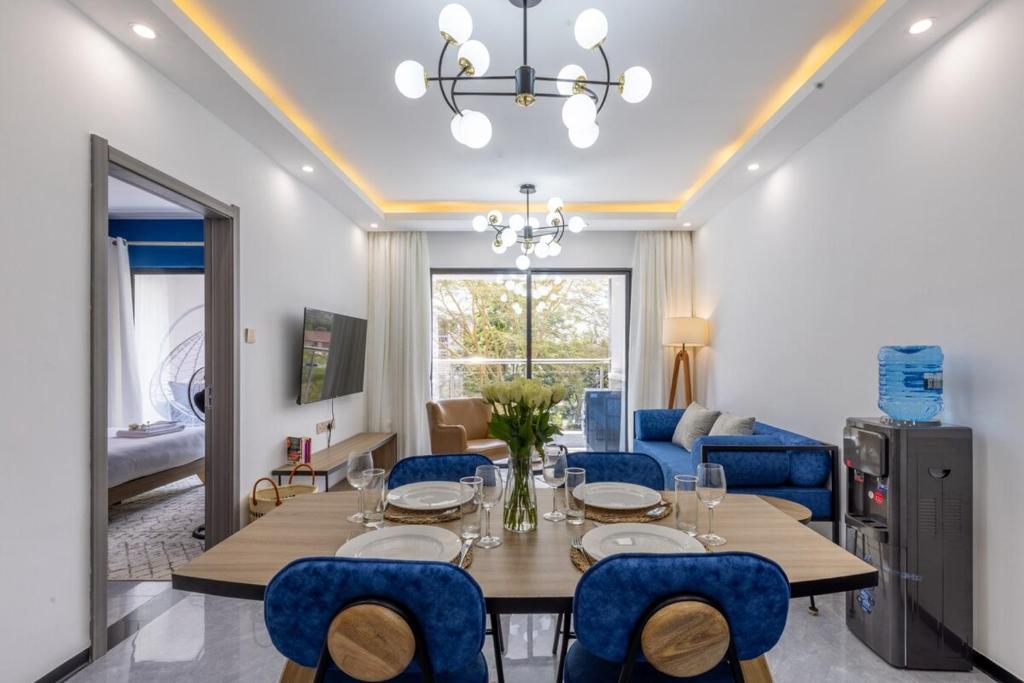 a dining room with a table and blue chairs at Nandwa IVY 1 Bed By YourHost Kileleshwa Nairobi in Nairobi