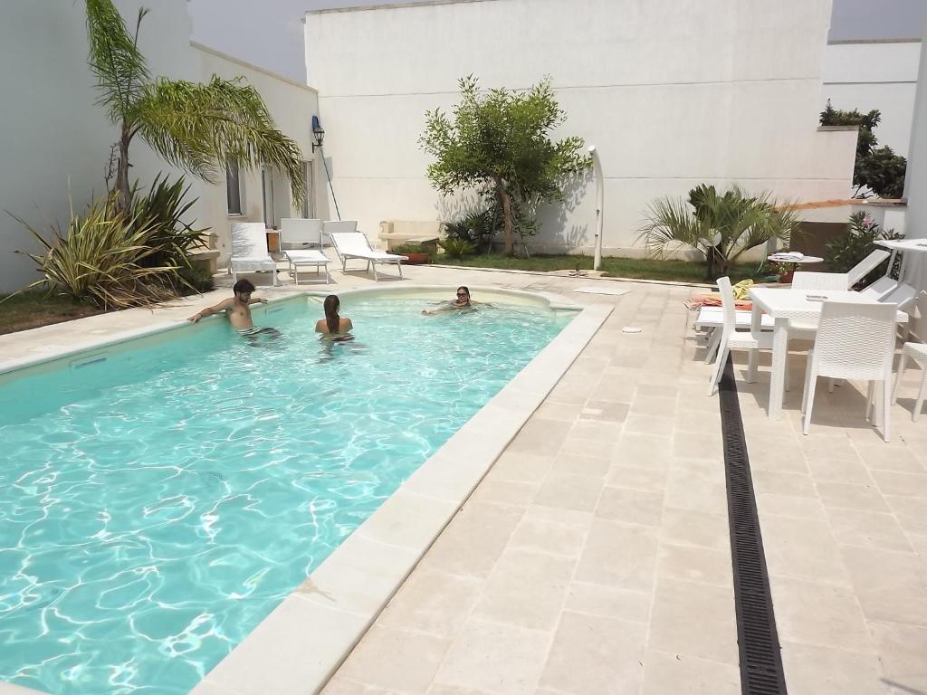 a group of people in a swimming pool at B&b La Balaustra in Andrano