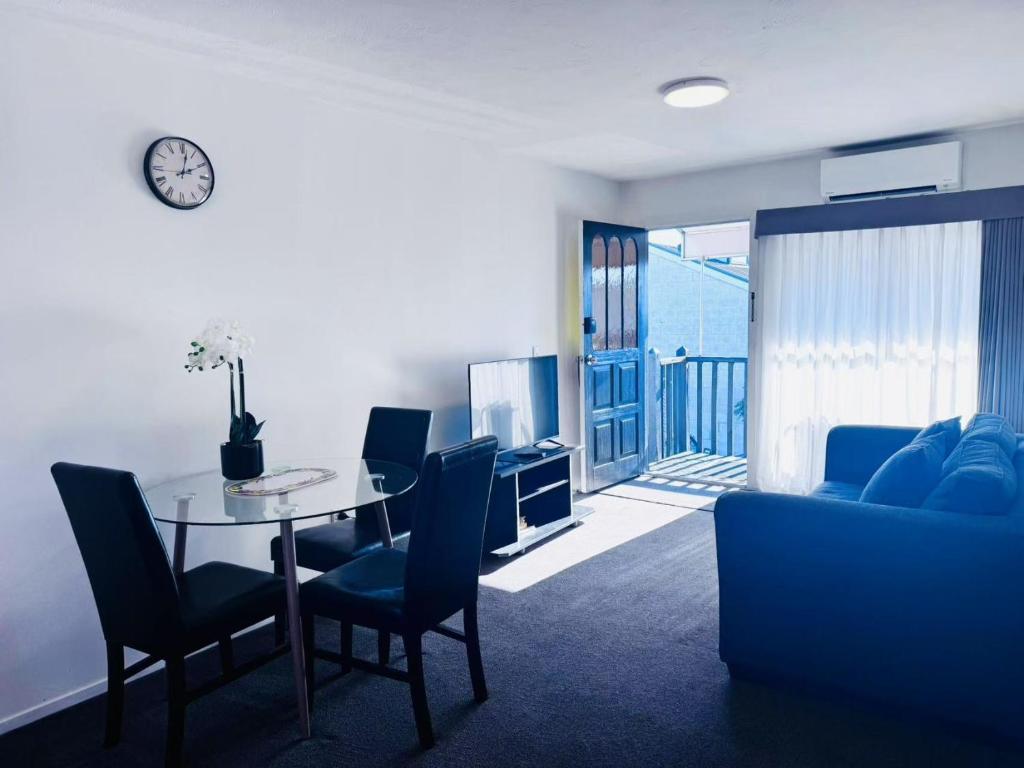 a living room with a table and a couch at Merivale Court One Bedroom Apartment in Christchurch