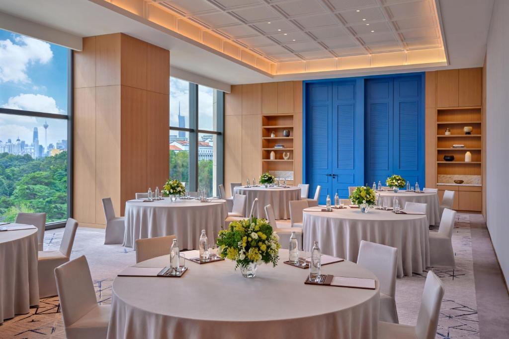 A bright event room with round banquet tables and a city-facing window wall.