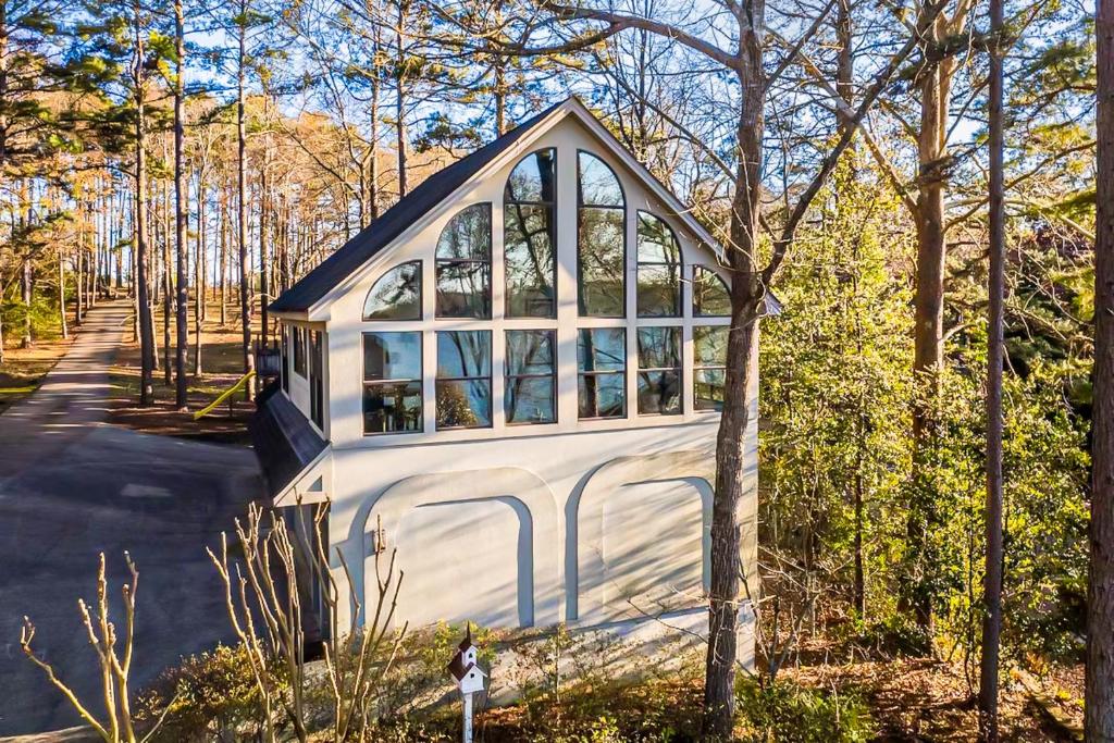 Casa blanca pequeña con ventana grande en Modern Treehouse with Views and Comfort, en Lake Hamilton