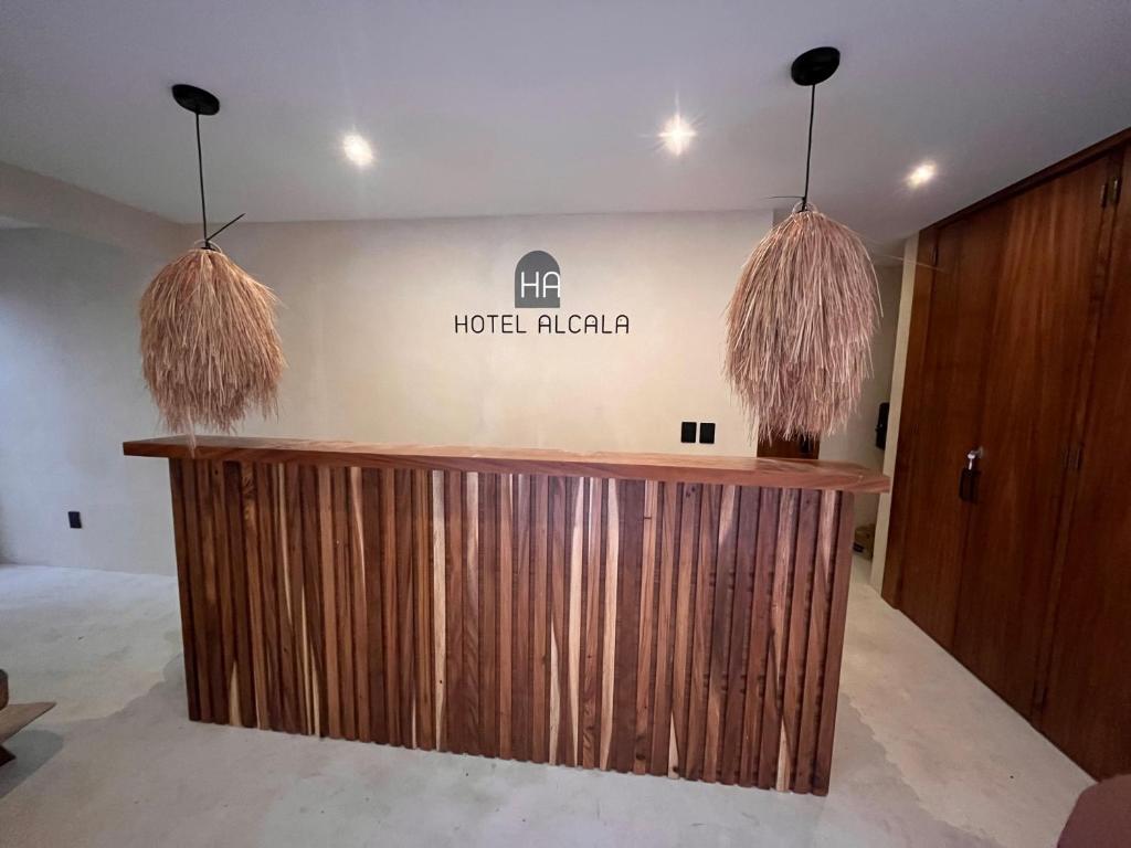 a hotel lobby with a wooden counter with two pendant lights at Hotel Boutique Alcalá Vallarta in Puerto Vallarta