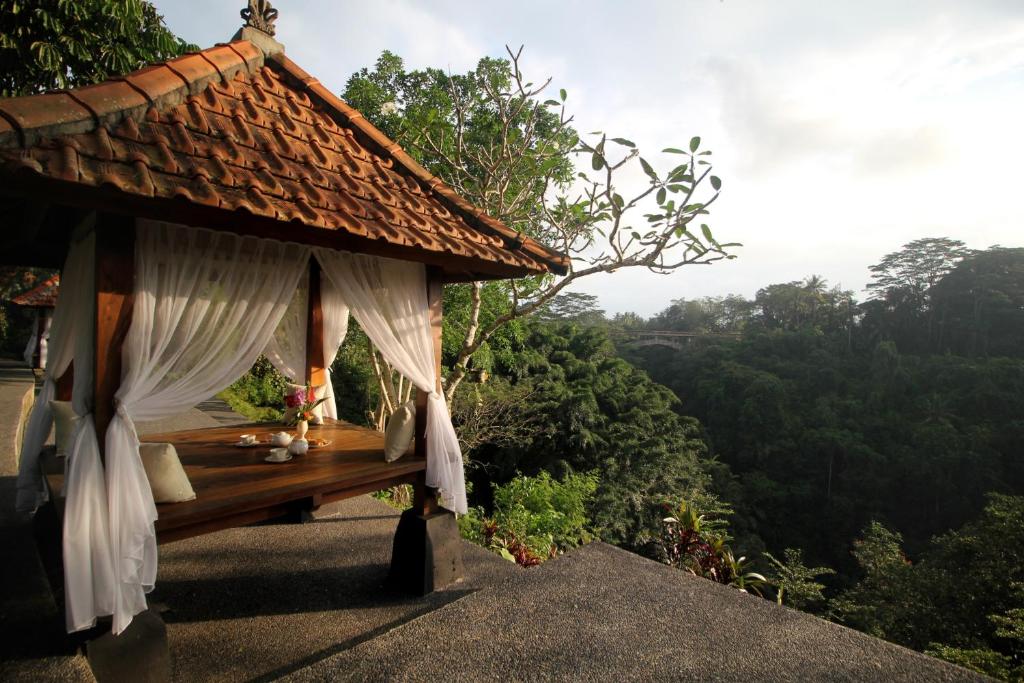 a resort with a table with curtains and a view at Tanah Wuk Villas near ubud in Sangeh
