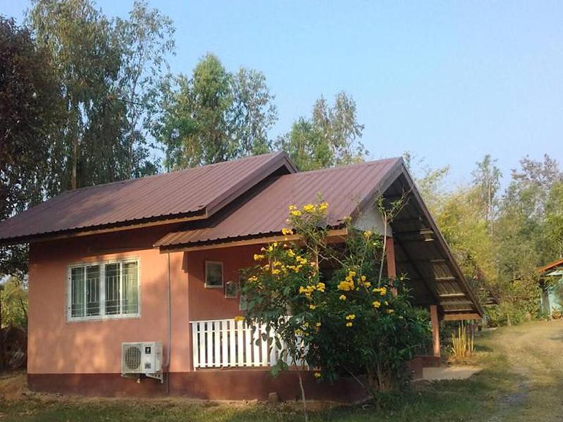 a small house with a brown roof and a bush at Ingna Resort in Chanuman