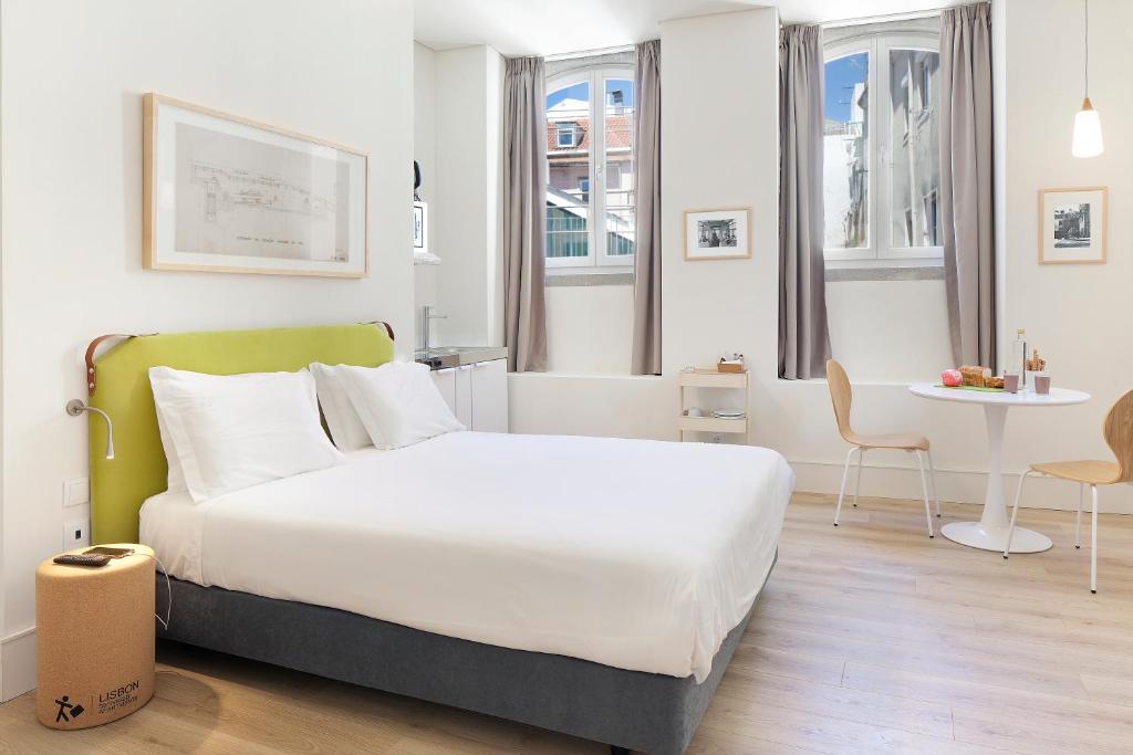 a hotel room with a large bed and a large window at Ascensor da Bica - Lisbon Serviced Apartments in Lisbon