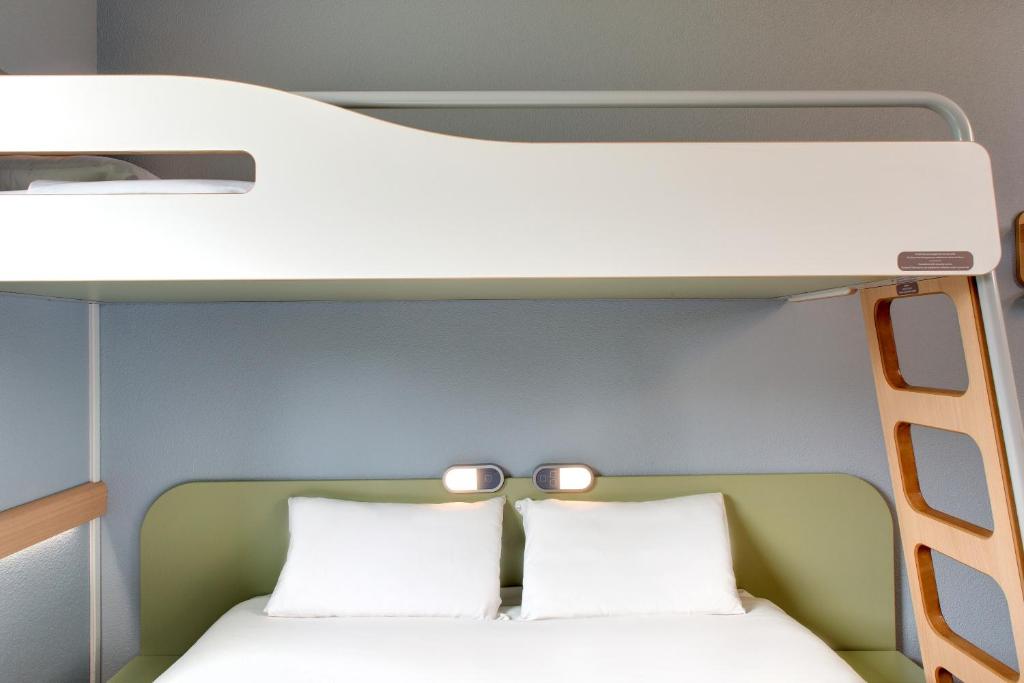 a bunk bed with two white pillows in a room at ibis budget Montceau les Mines in Montceau-les-Mines