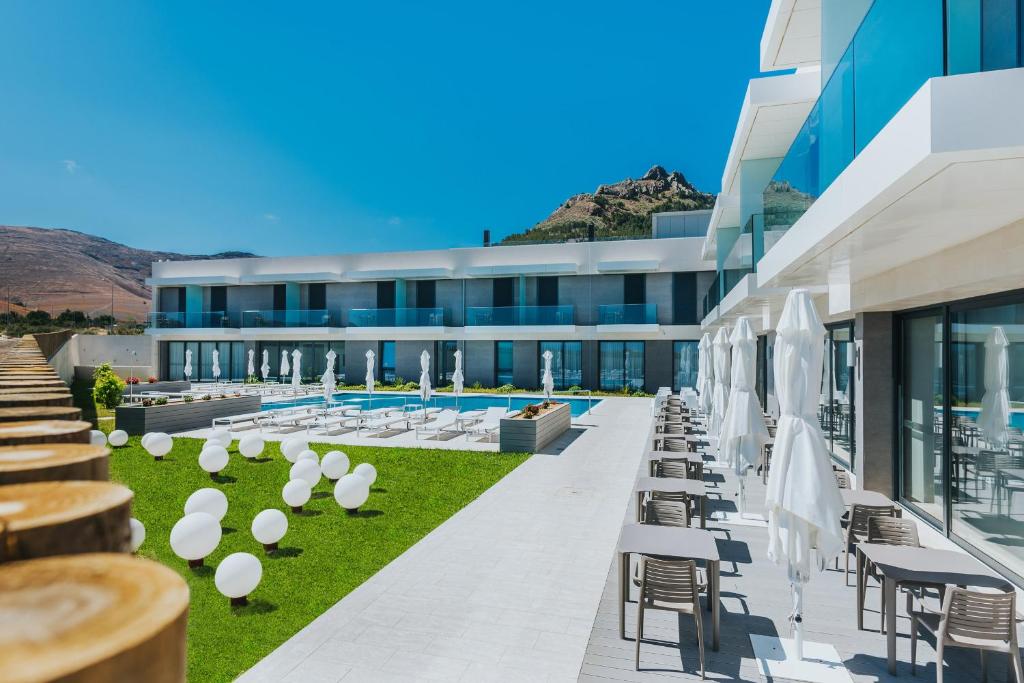 an exterior view of a building with chairs and umbrellas at Vila Baleira Village in Porto Santo