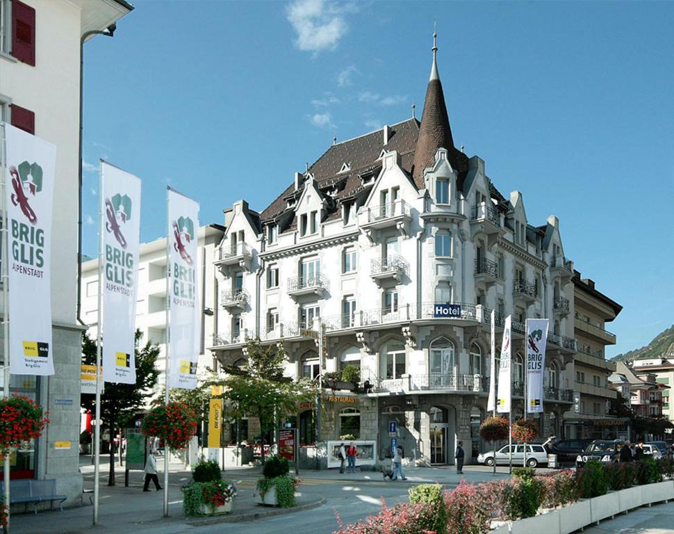 un grande edificio bianco su una strada cittadina di Hotel Victoria a Brig