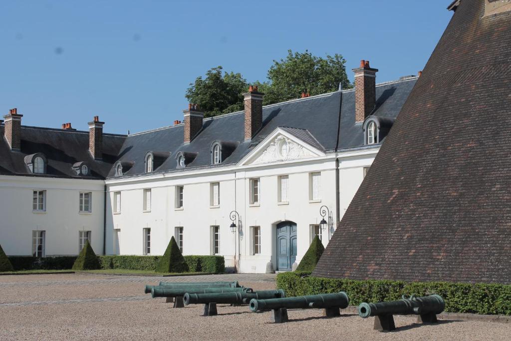 a large white building with cannons in front of it at ibis budget Montceau les Mines in Montceau-les-Mines