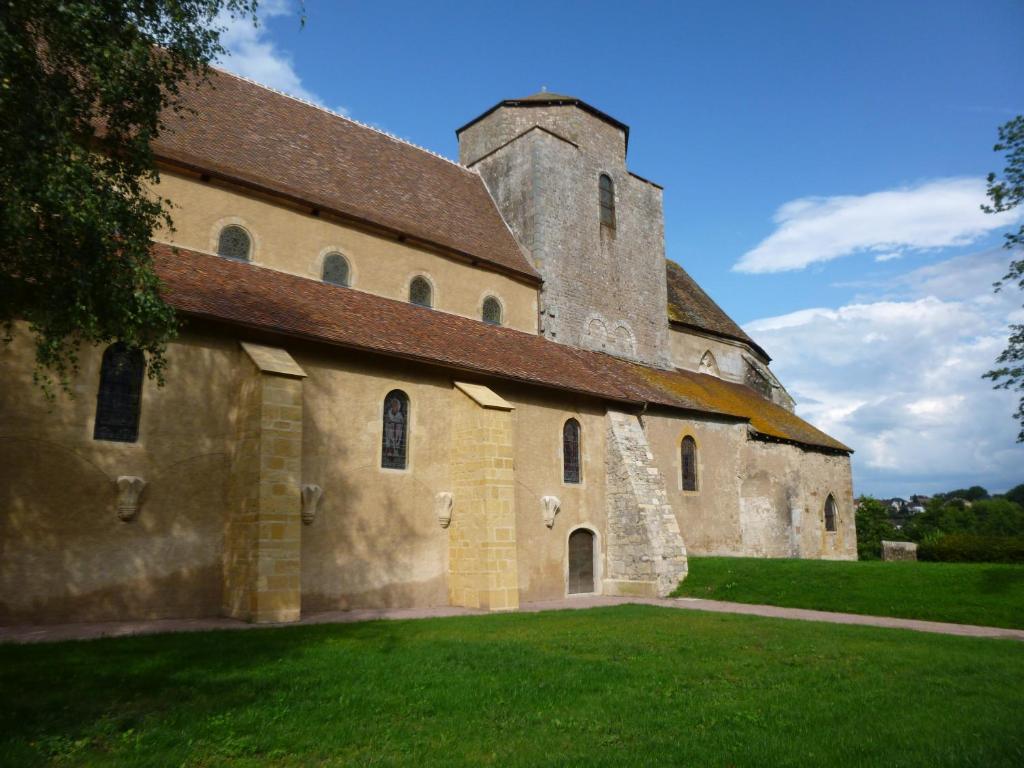 a large stone building with a tower on a grass field at ibis budget Montceau les Mines in Montceau-les-Mines