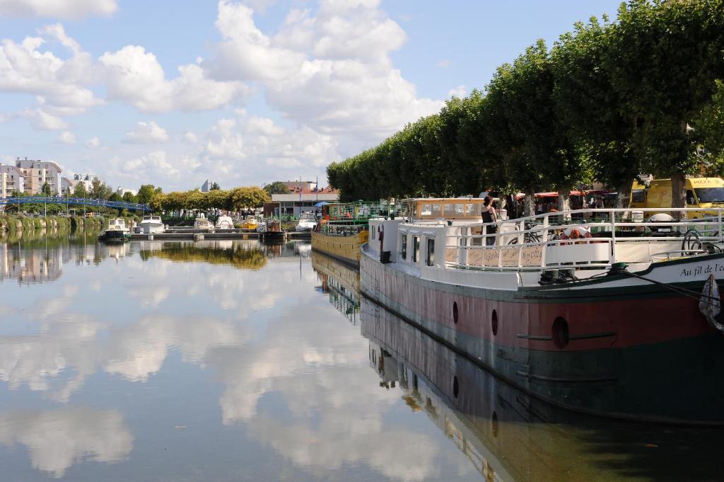 a boat is docked in a river with other boats at ibis budget Montceau les Mines in Montceau-les-Mines
