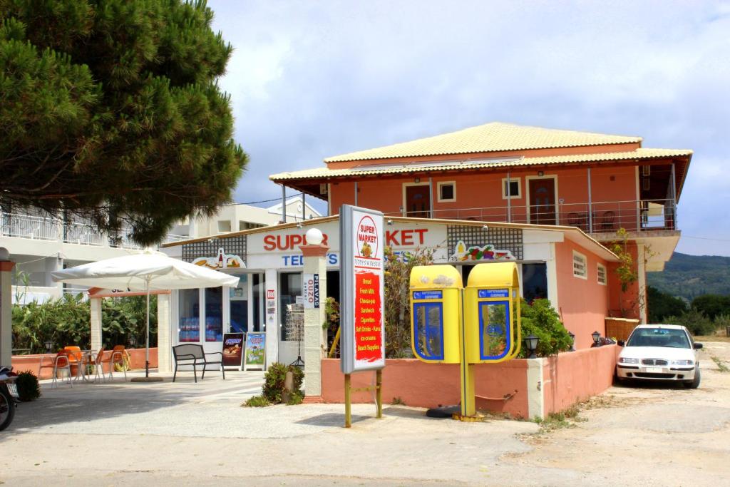 a store with two old fashioned telephone booths in front of it at Seaview in Agios Georgios