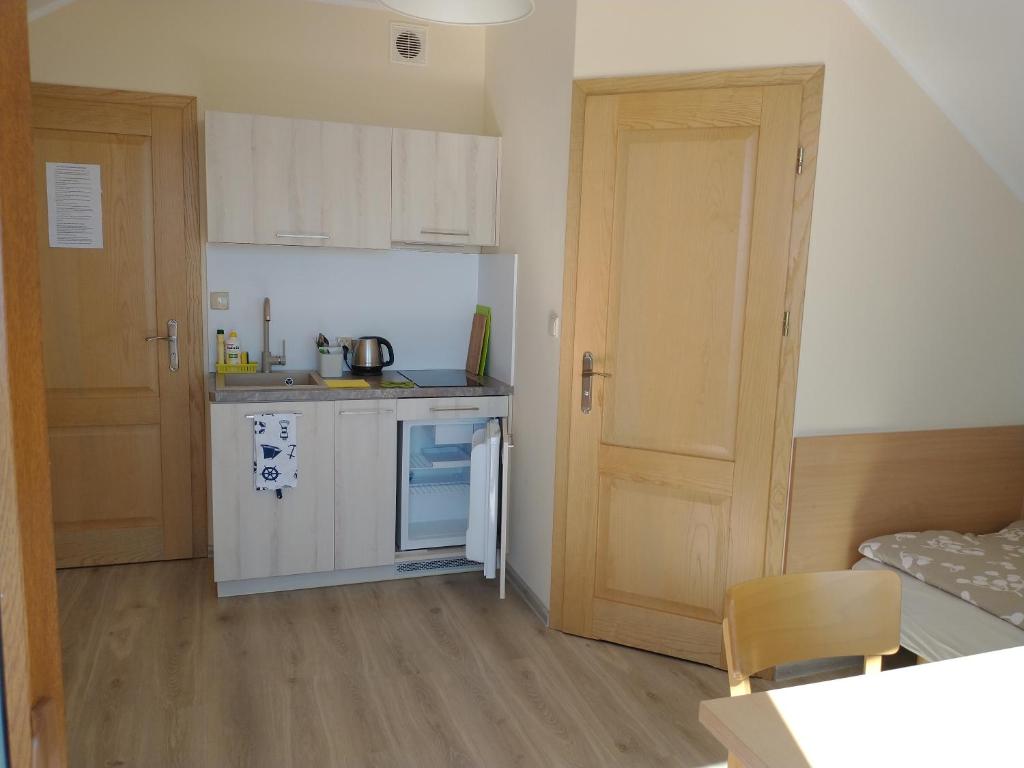 a small kitchen with a sink and a refrigerator at Nad zatoką in Kuźnica