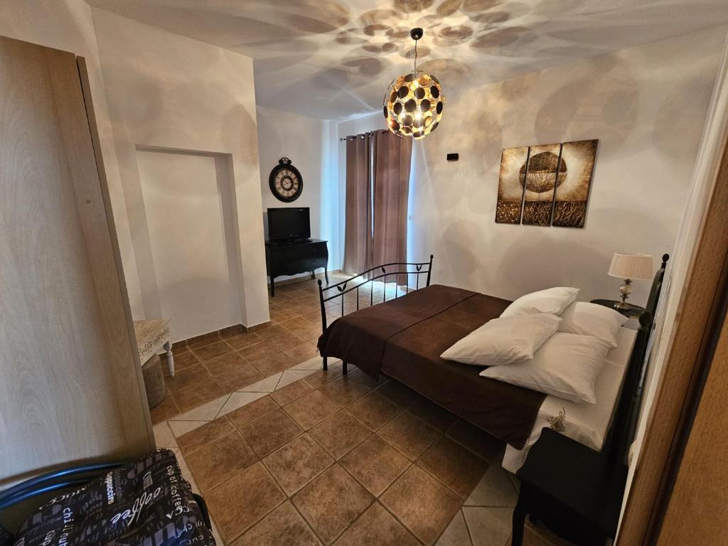 a bedroom with a bed and a room with a clock at Apartmani Katja in Omiš