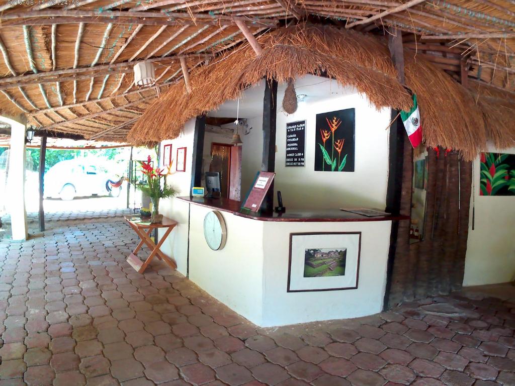 a restaurant with a counter with a straw roof at Hotel Cabañas Safari in Palenque