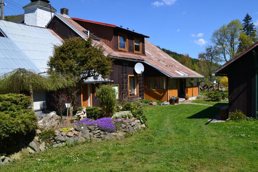 una casa con un jardín con flores delante en Lodge U Mařenky A Jeníčka, en Ludvíkov