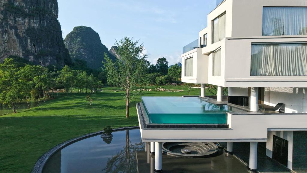 ein Haus mit Swimmingpool und Golfplatz in der Unterkunft YINGMAN HOTEL in Yangshuo