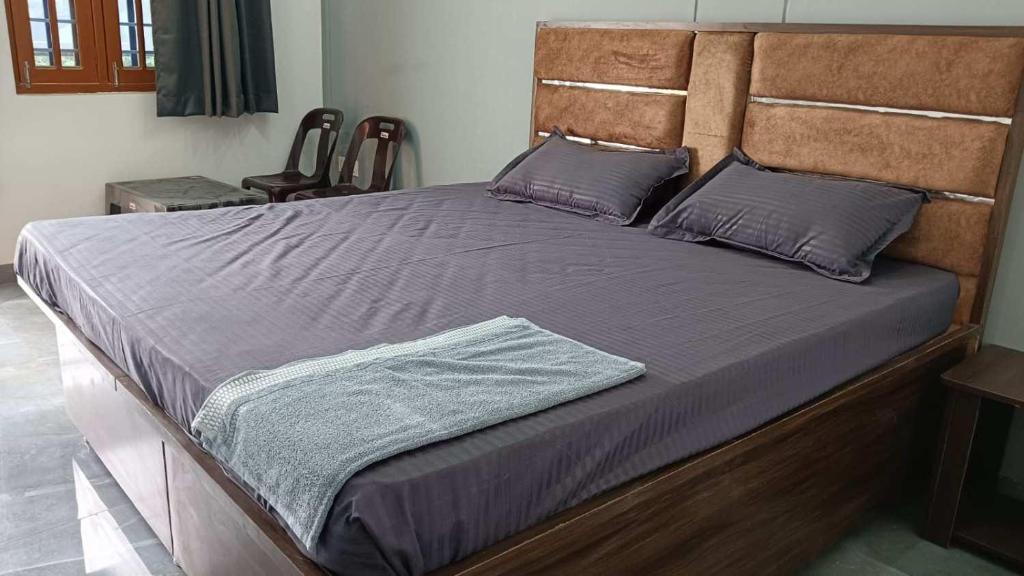 a large bed with purple sheets and pillows at Omanshi Homestay in Hamīrpur