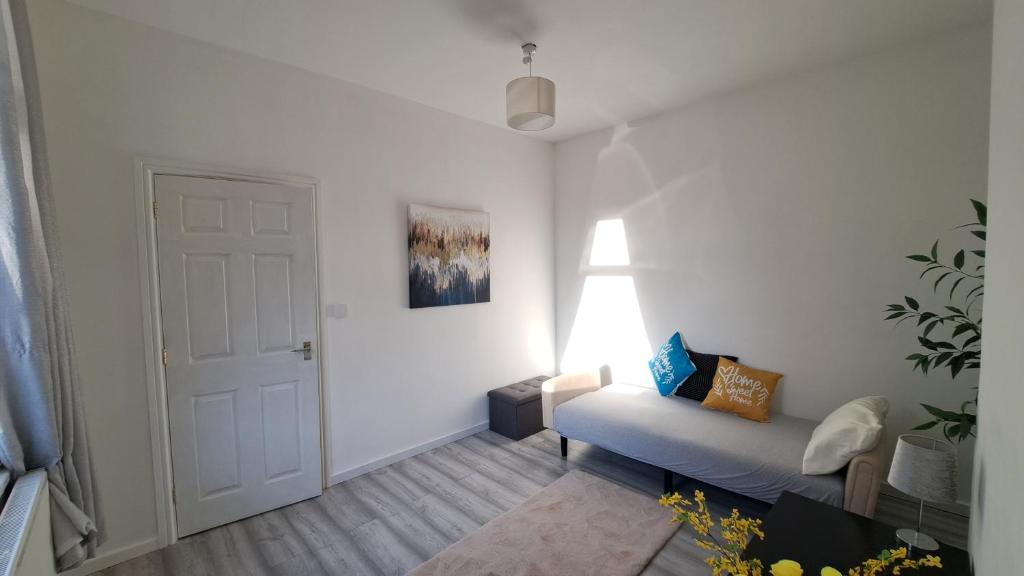 a white living room with a couch and a door at 2 bedroom Large House For Contractors, And Family with a sofa bed in Shildon