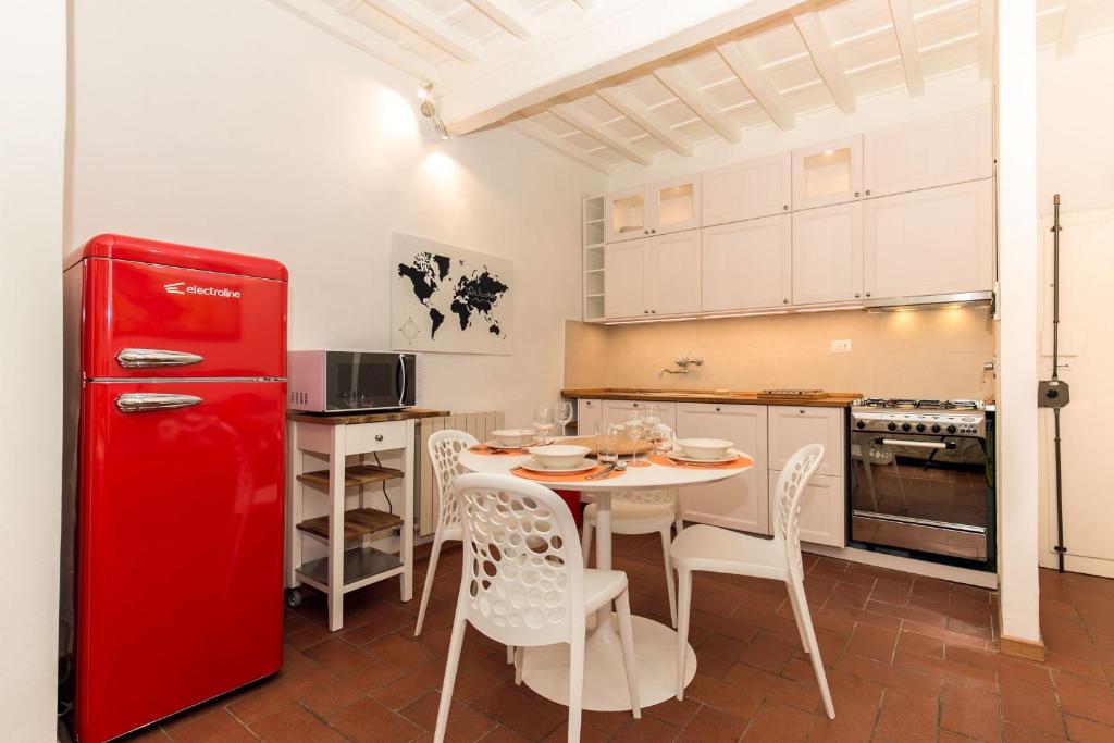 フィレンツェにあるPinocchio Houseのキッチン(赤い冷蔵庫、テーブル、椅子付)