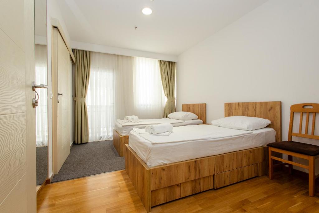 a bedroom with two beds and a chair at Hotel PIO in Ulcinj