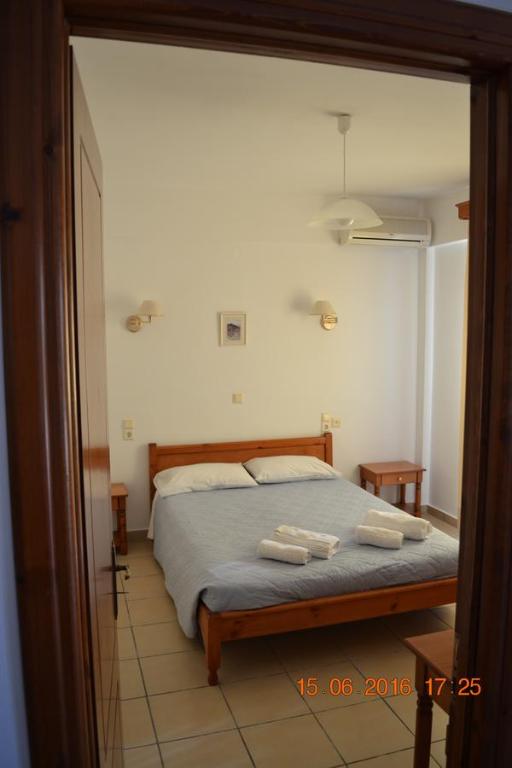 sypialnia z łóżkiem i dwoma ręcznikami na nim w obiekcie Molivos Castle Apartments w mieście Mythimna